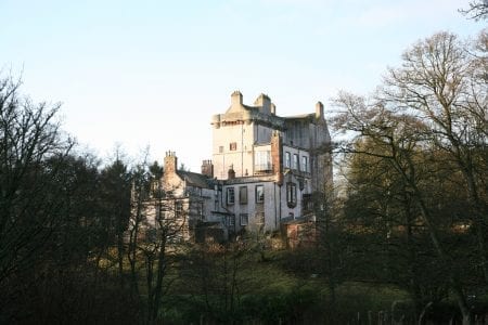 Delgatie Castle's tower rising above bare winter trees.