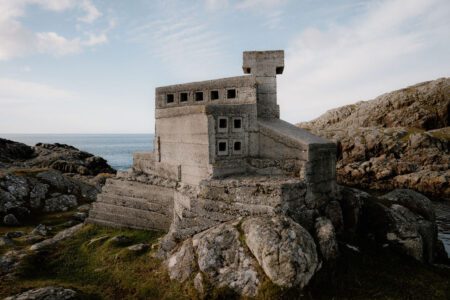 Concrete lookout tower perched on rocky coastline overlooking the sea