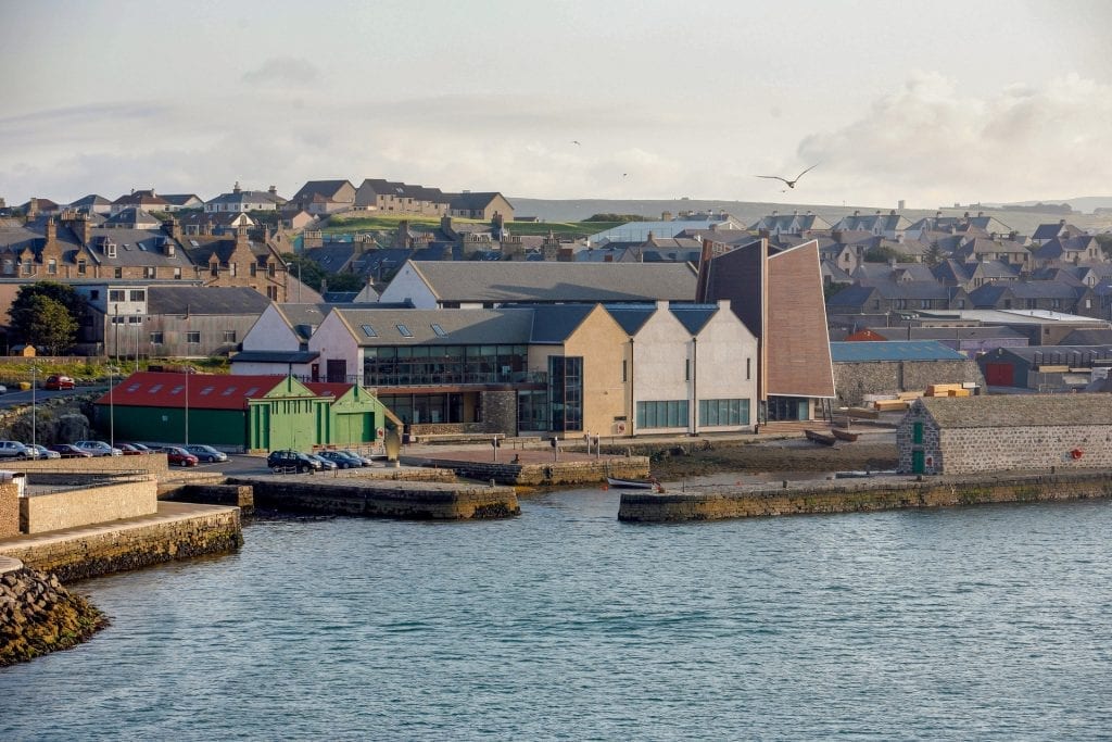 Hay's Dock and the museum below the rooftops of Lerwick, a gull overhead.