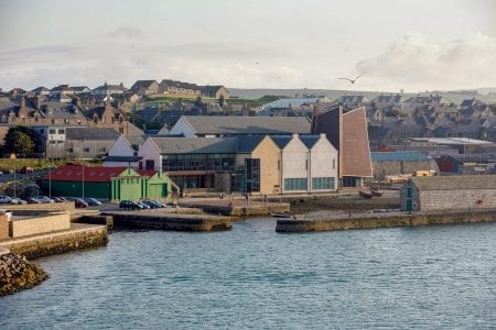 Hay's Dock and the museum below the rooftops of Lerwick, a gull overhead.