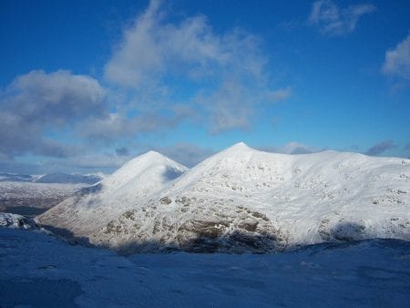 Ben More and Stob Binnein white with snow under a blue sky.