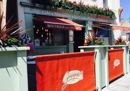Giacopazzi's café and Boutique del Gelato, with orange awnings and planters outside