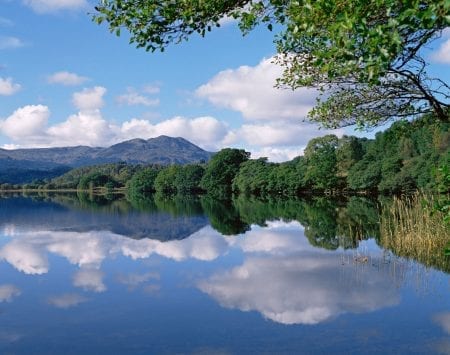 Loch Venachar's still water between wooded hills.