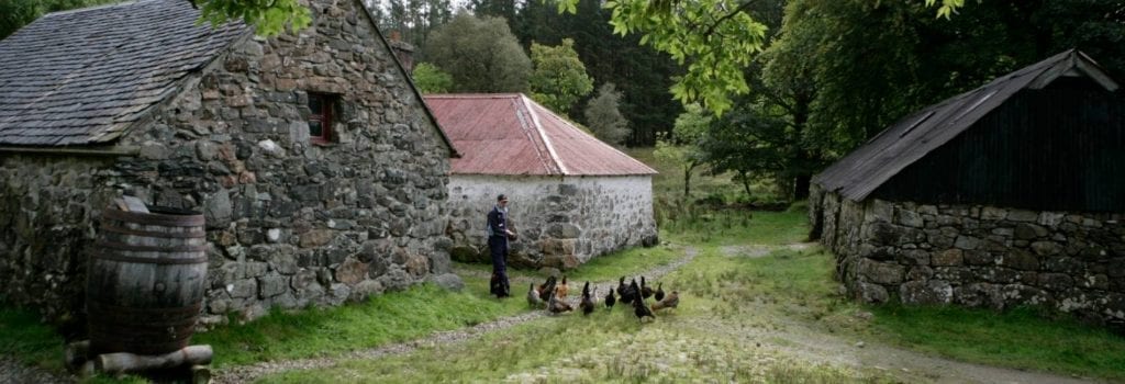 Stone buildings of Auchindrain with hens in the yard.