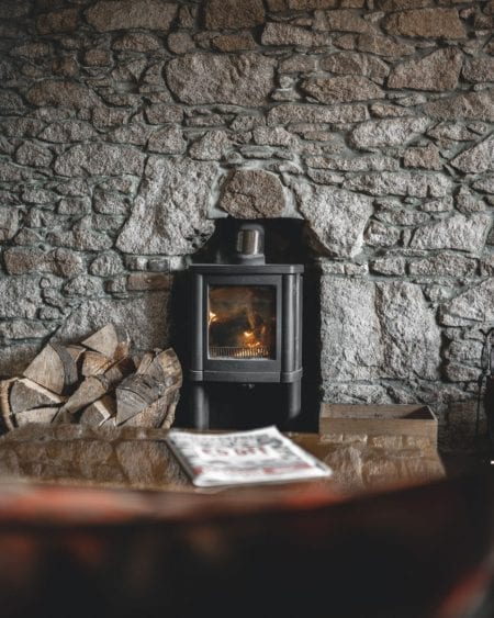 A wood-burning stove set into an old stone wall at the Kilmarnock Arms.