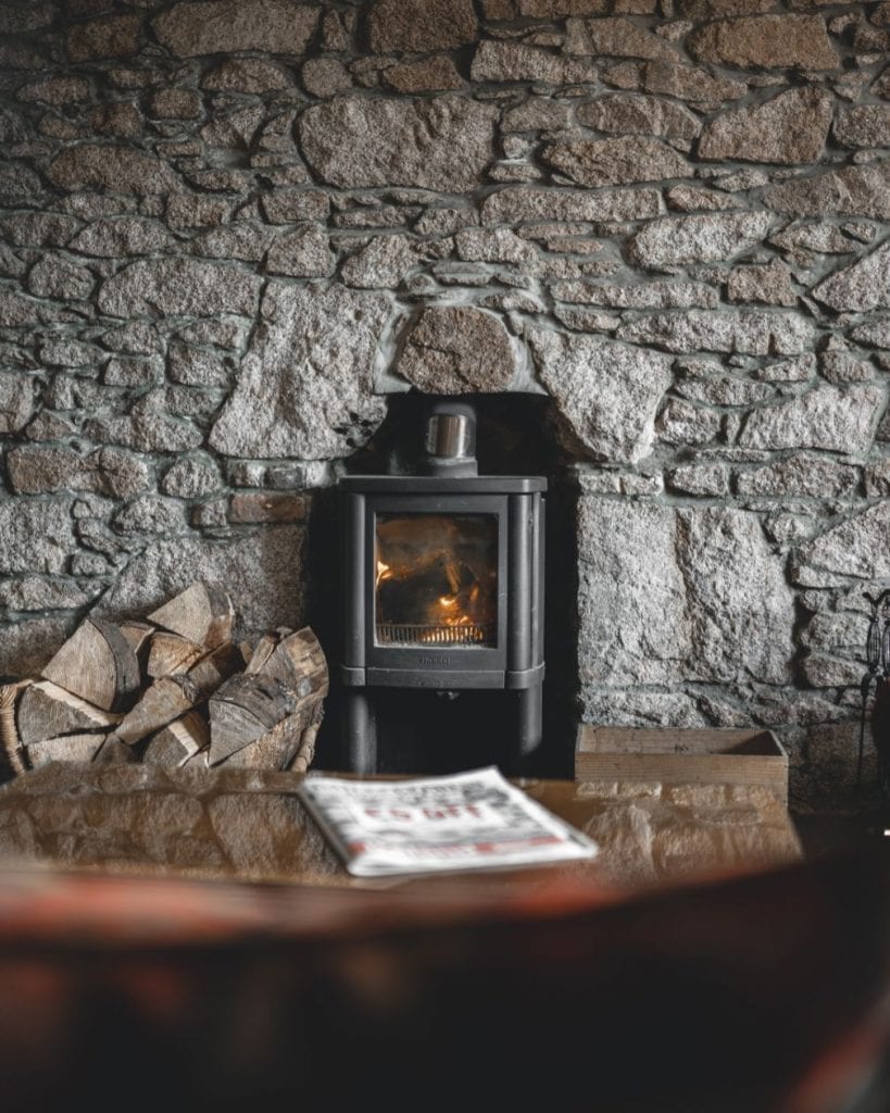 A wood-burning stove set into an old stone wall at the Kilmarnock Arms.