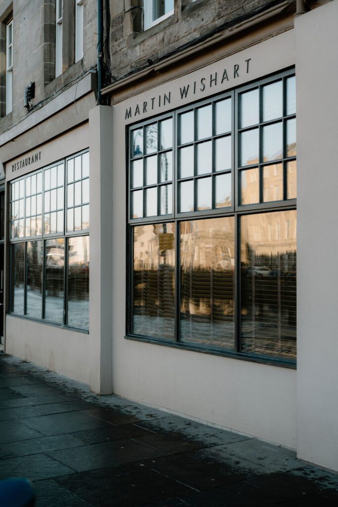 Restaurant Martin Wishart's white frontage with large paned windows on Leith's waterfront