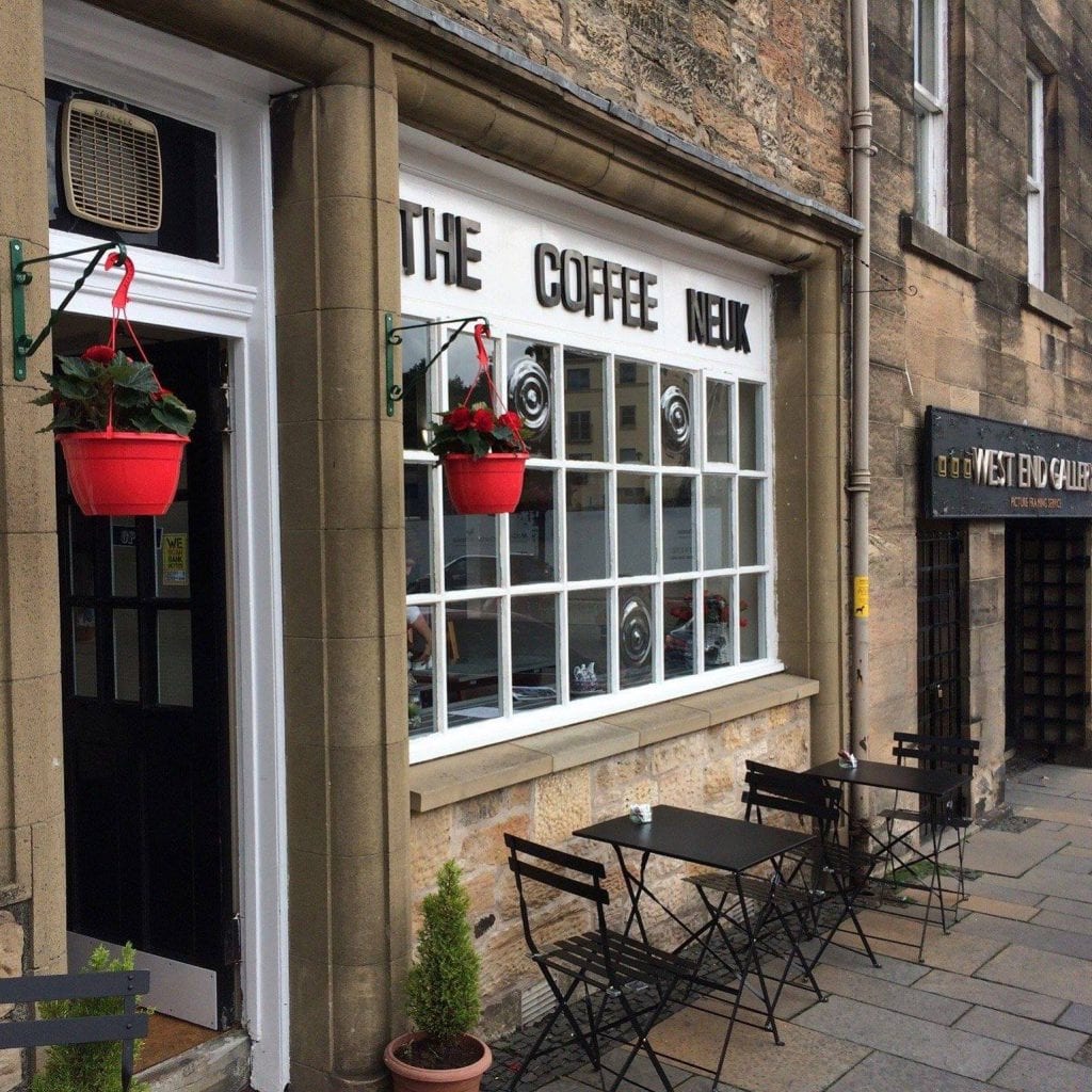The Coffee Neuk shopfront with red hanging baskets and pavement tables
