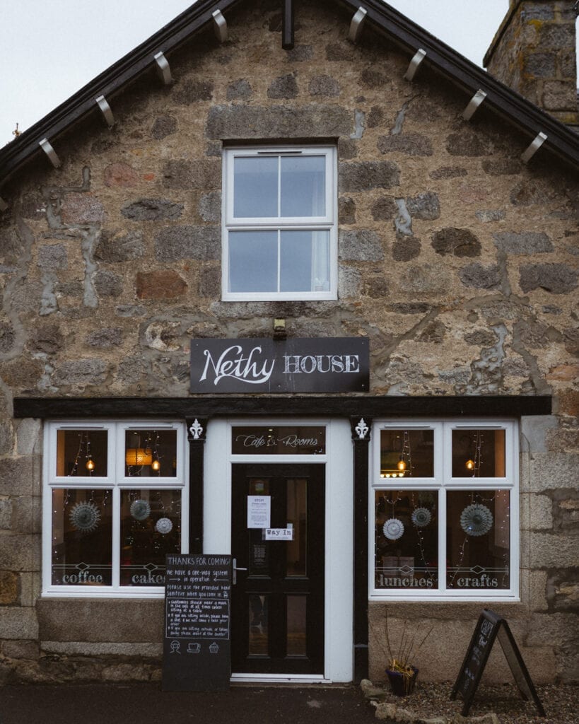 Stone-fronted Nethy House café, with signs for coffee, cakes, lunches and crafts