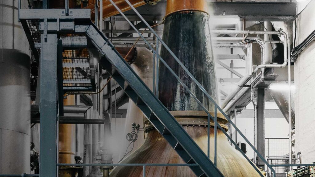 The tall copper stills in Fettercairn's stillhouse, among steel walkways.