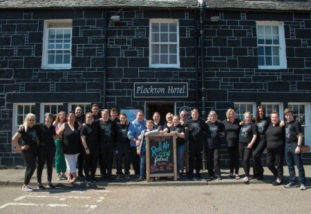 Staff and guests gather outside the Plockton Hotel for a group photo