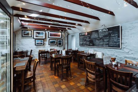 Tables and chairs in the wood-panelled room at the Antlers in Craighouse.