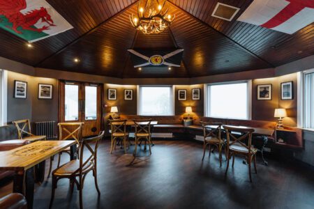 The Jura Hotel's restaurant with its tables laid under a painted ceiling.
