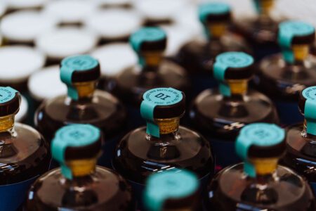 Rows of Deer Island rum bottles with turquoise caps.