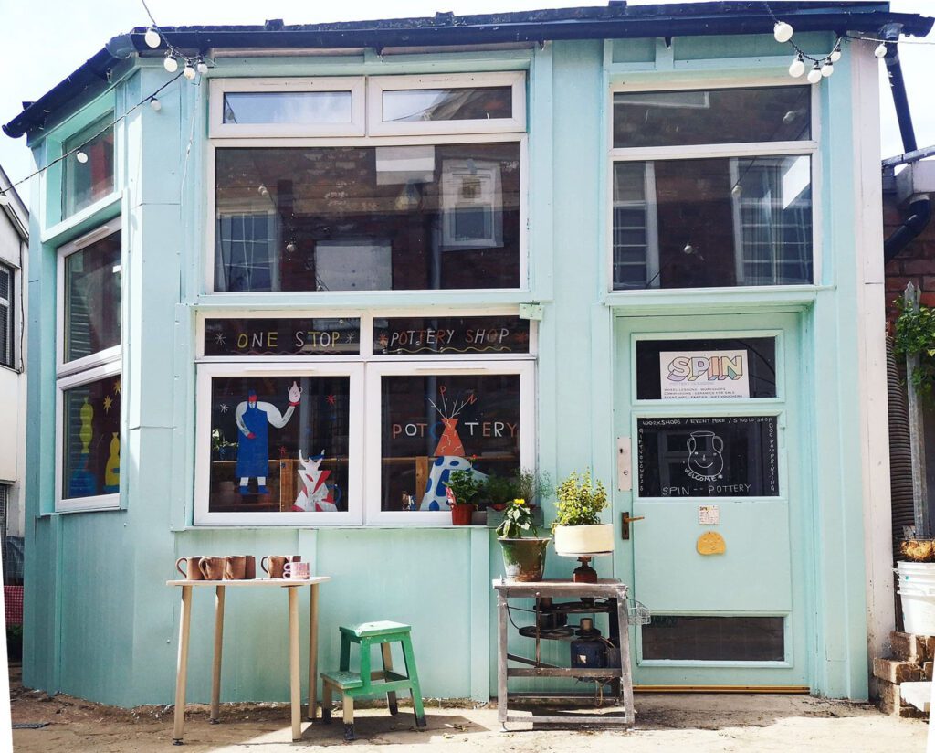 Spin Pottery's pale blue studio in the Hidden Lane, plants at the door.