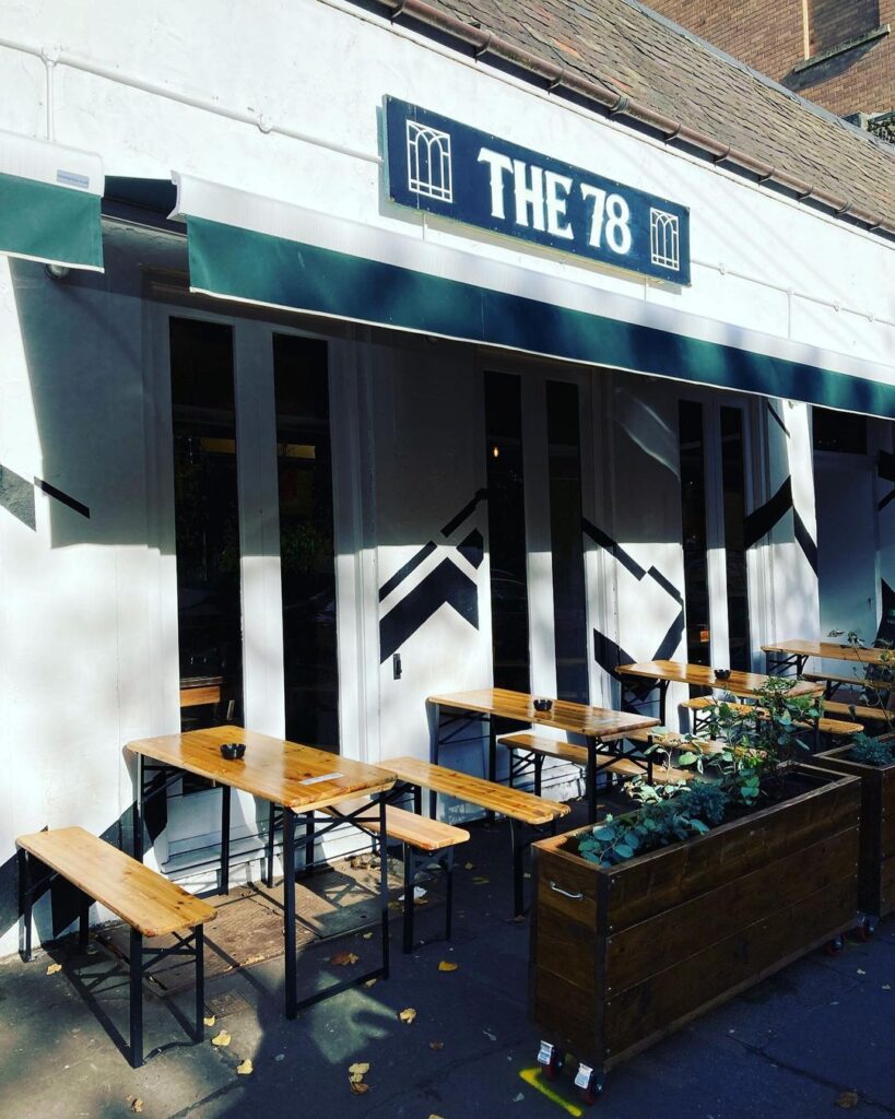 The 78's black and white front with tables on the pavement.