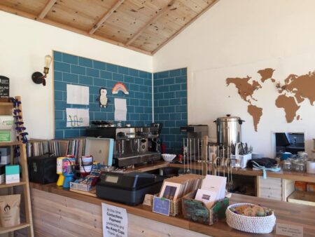Café counter with espresso machine, blue tiled wall and world map mural
