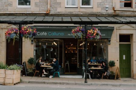 Café Calluna storefront with hanging flower baskets and diners seated outside