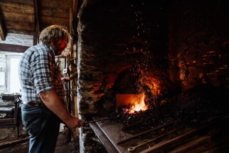 The blacksmith at the glowing forge.