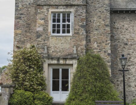 Stone tower with sash window above a white-framed door and lantern