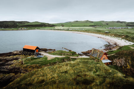 The sandy crescent of Dunaverty Bay under a grey sky.