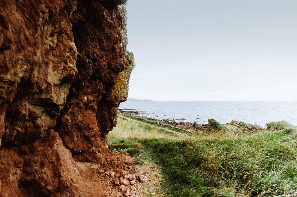 The mouth of a sea cave at Keil, opening on grass and sea.
