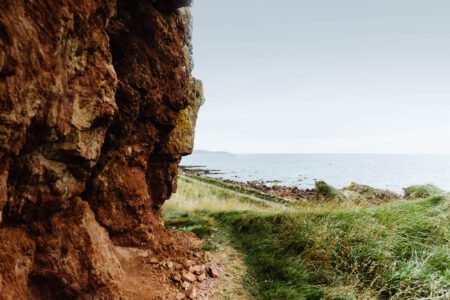 The mouth of a sea cave at Keil, opening on grass and sea.
