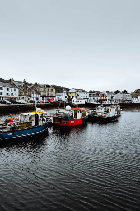 Fishing boats OB51 and ME moored in Tarbert harbour, waterfront buildings behind
