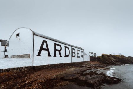 Ardbeg distillery's whitewashed warehouse wall beside the rocky Islay shore
