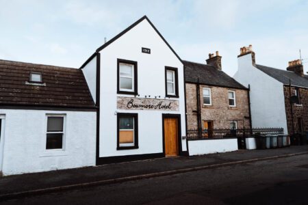 The whitewashed front of the Bowmore Hotel on Jamieson Street, its name across the gable.