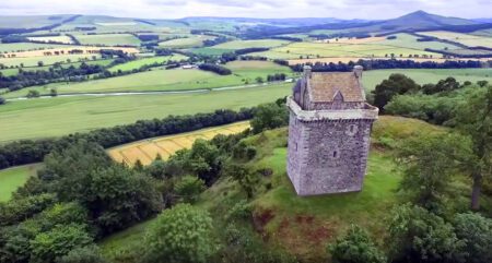 Stone tower overlooking patchwork farmland and a winding river valley