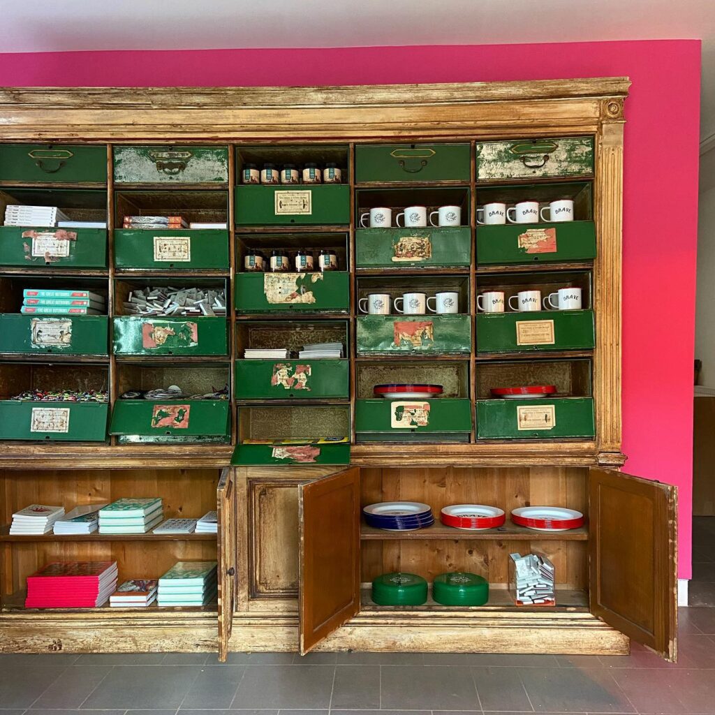 An old painted dresser of enamelware and boxes against a pink wall in the Glen Dye Shop.