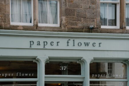 Sage green shopfront reading "paper flower" at number 37