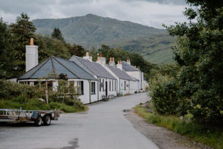 Whitewashed cottages line a quiet road beneath a mountain ridge