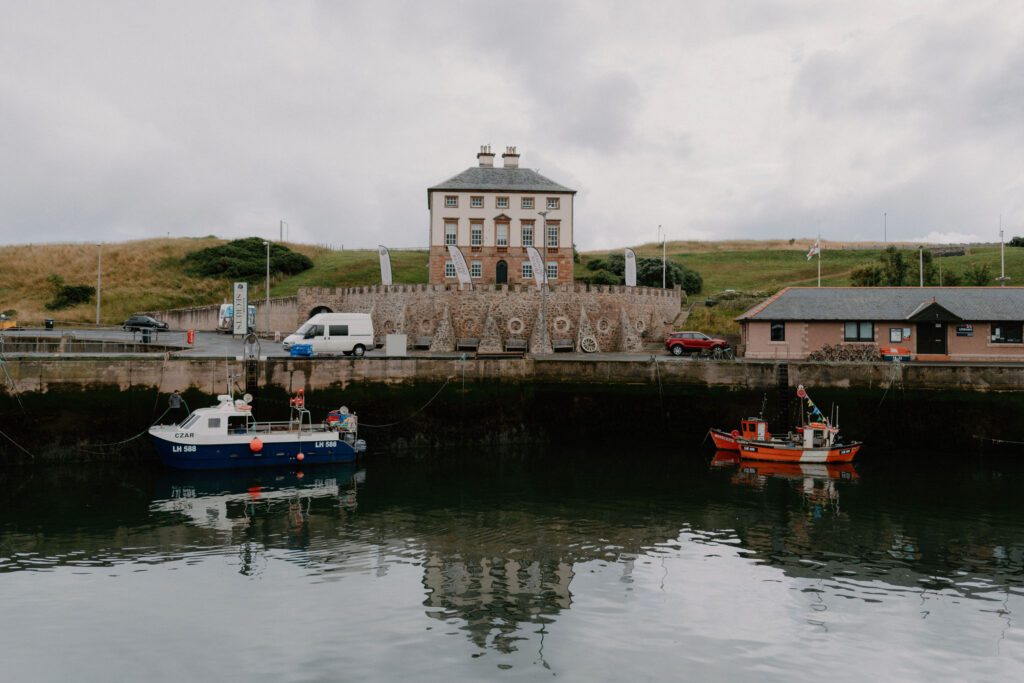 Fishing boats moored in Portsoy harbour beneath the grand harbourmaster's house