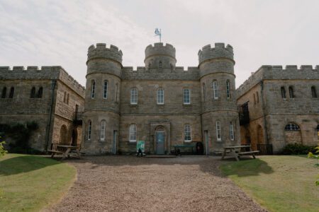 Turreted stone castle with a flag flying above the central tower
