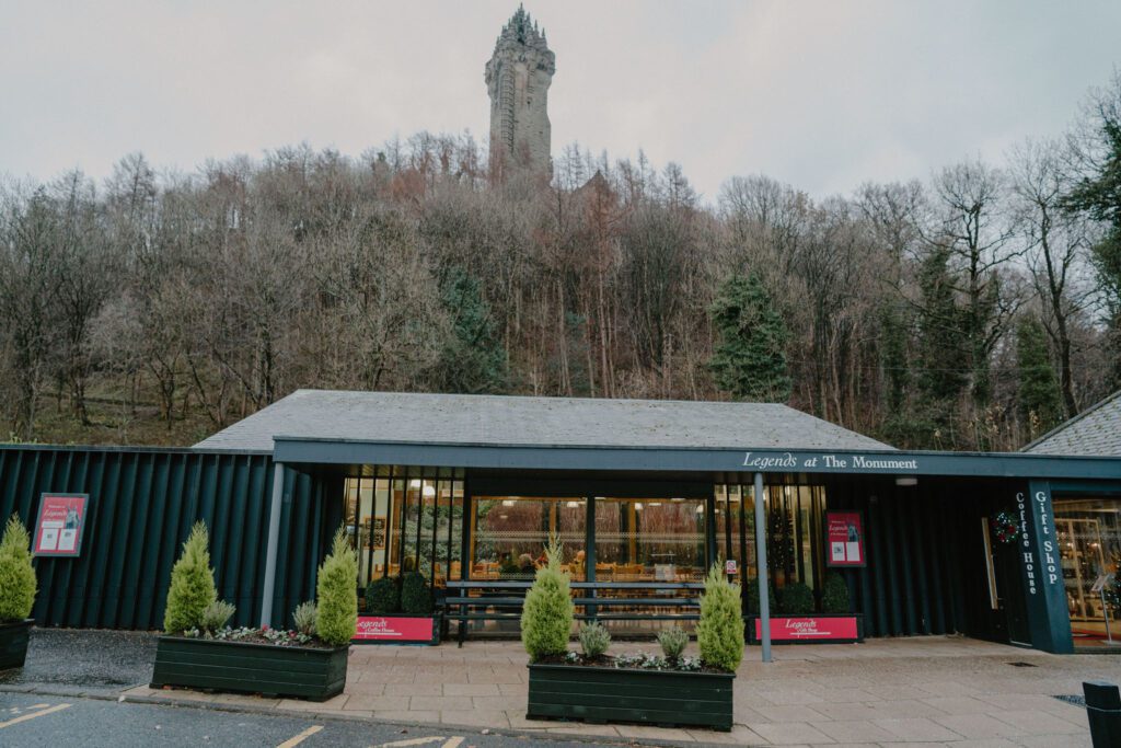 Legends at the Monument's long timber building, the Wallace Monument on the Abbey Craig above.