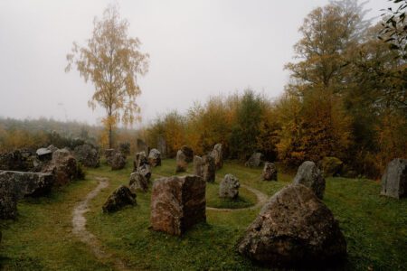 Standing stones arranged in circles on a misty autumn hillside