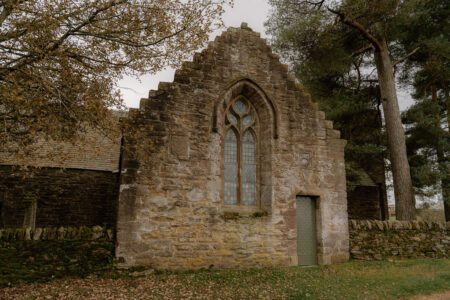 Stepped gable end of a stone chapel with a tall arched window