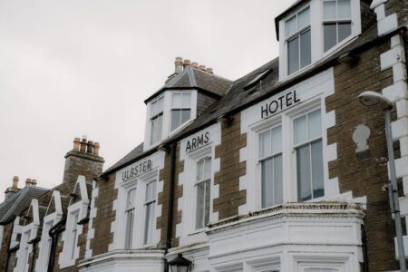 Sandstone facade of the Ulbster Arms Hotel with white bay windows and chimneys