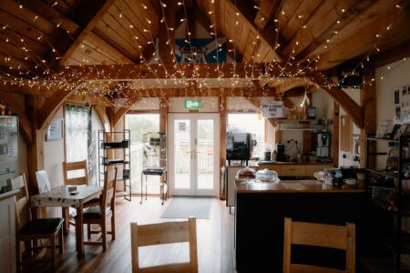 Timber-framed café interior with fairy lights strung across exposed roof beams