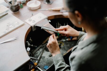Jeweller files a ring at a workbench fitted with a leather catch tray