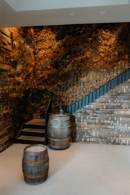 Wooden barrels beside a staircase with an autumn forest mural backdrop