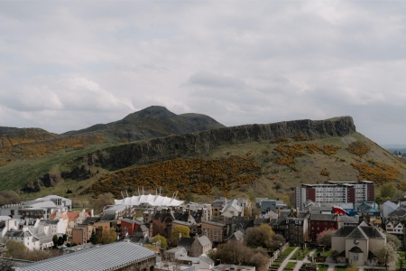Salisbury Crags and Arthur's Seat rise above Edinburgh's rooftops and Dynamic Earth's white tented roof