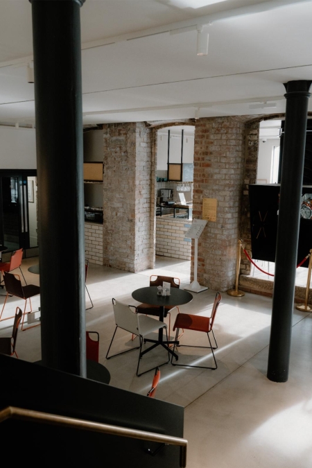 Exposed brick pillars and café tables inside a converted industrial building