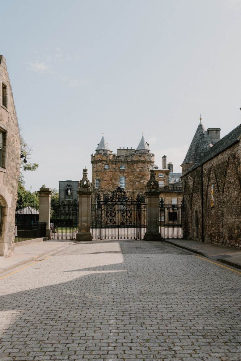 Wrought-iron gates lead to the turreted towers of Holyroodhouse Palace
