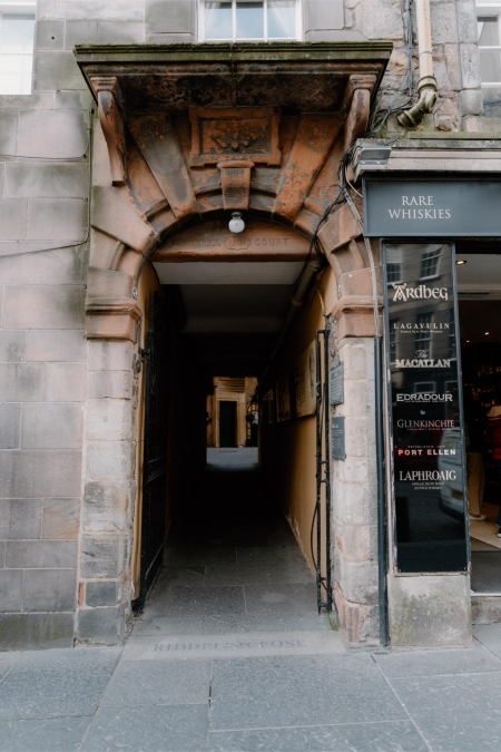 Stone archway close, with a "Rare Whiskies" sign listing Ardbeg, Laphroaig and Macallan