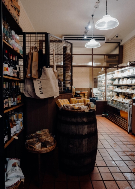 The shop inside, with a barrel, shelves and hanging lamps.