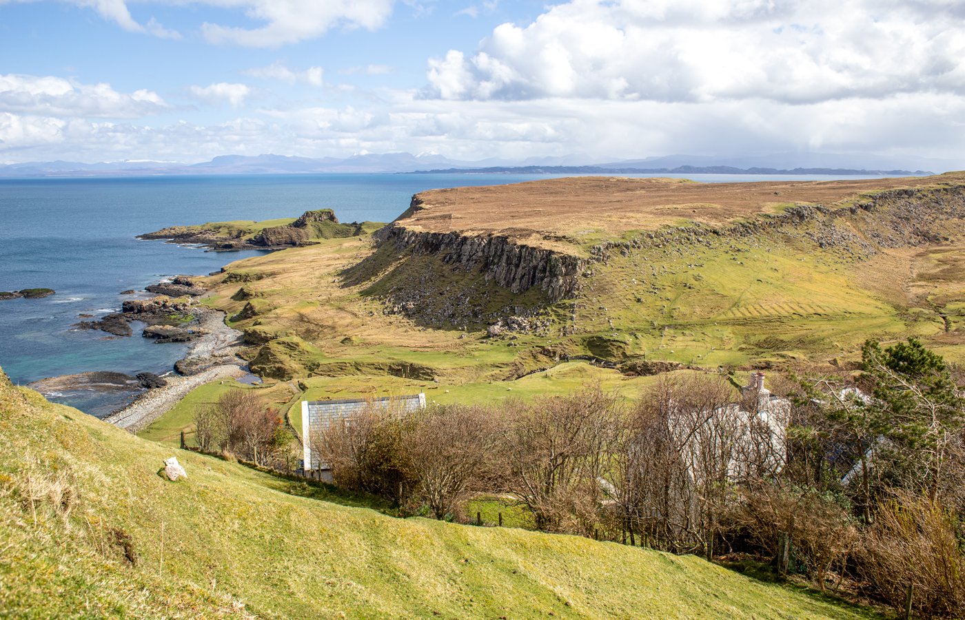 The Trotternish coast from above Half of One, cliffs and green headlands running out into the sea.