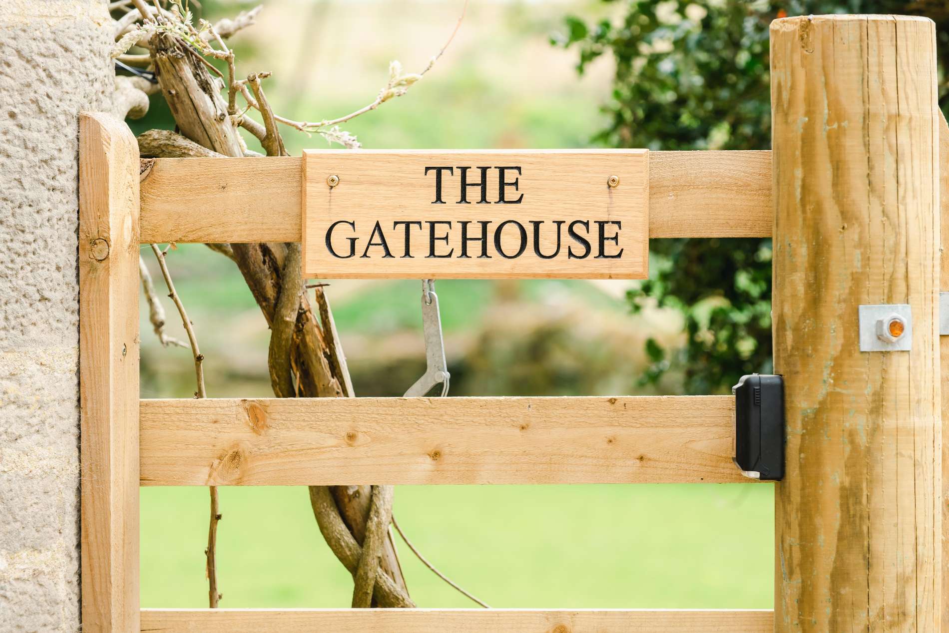 A wooden sign fixed to a gate reads "THE GATEHOUSE".
